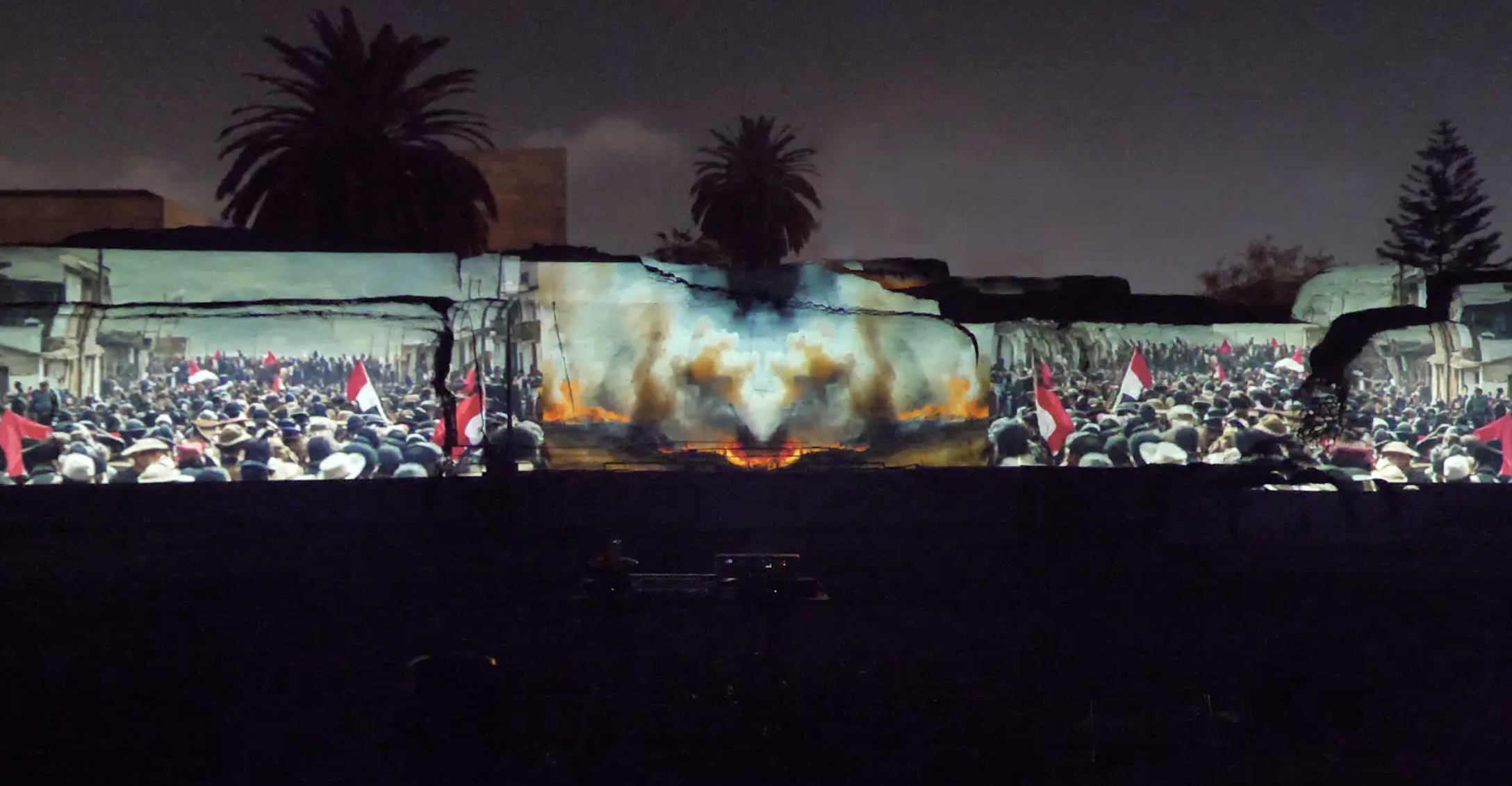 Video Projection displaying many people waving flags alongside images of fire and smoke