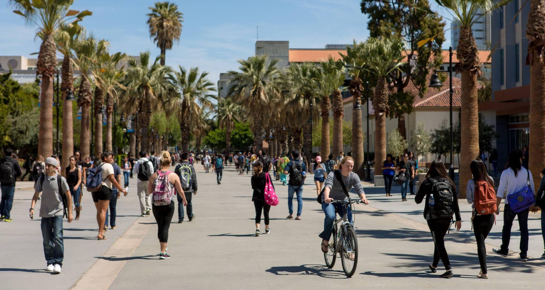 Photo, students walking on campus. Crowded area. 